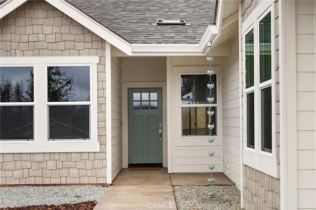 doorway to property featuring roof with shingles