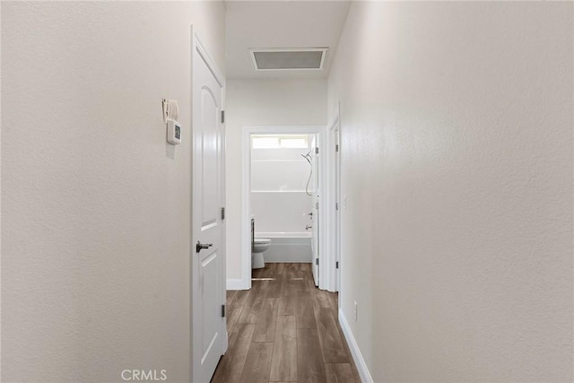 hallway with wood finished floors and baseboards