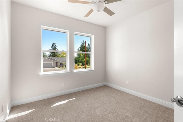 carpeted empty room with baseboards and a ceiling fan