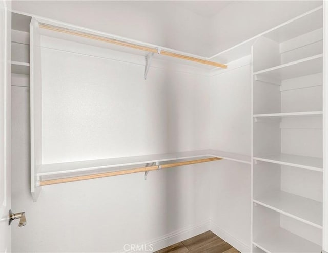 walk in closet with wood finished floors