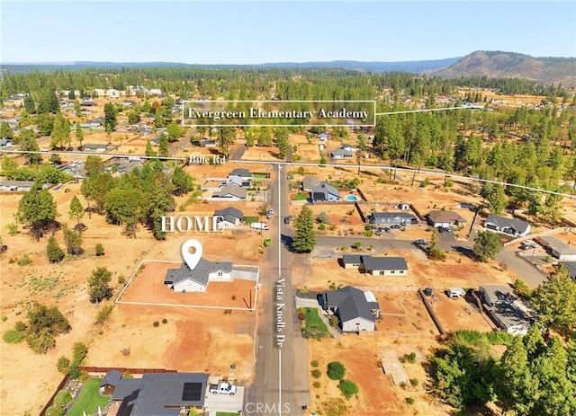 birds eye view of property featuring a mountain view and a view of trees