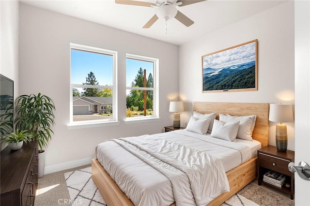 bedroom featuring light carpet, ceiling fan, and baseboards