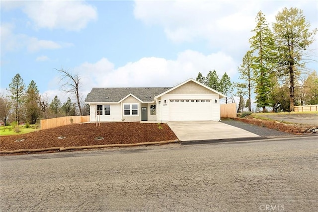 ranch-style home with driveway, an attached garage, and fence