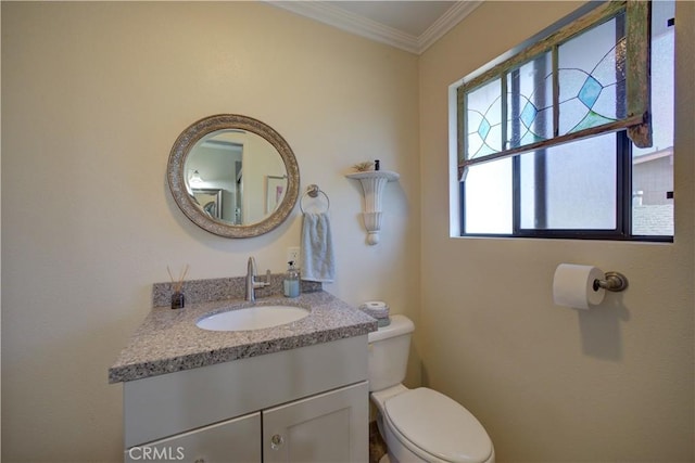 bathroom featuring toilet, vanity, and ornamental molding