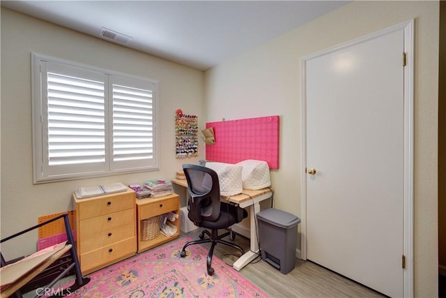 home office featuring light wood finished floors and visible vents