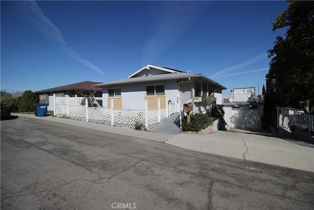 ranch-style house with driveway and fence