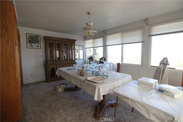 carpeted dining space featuring a notable chandelier and plenty of natural light