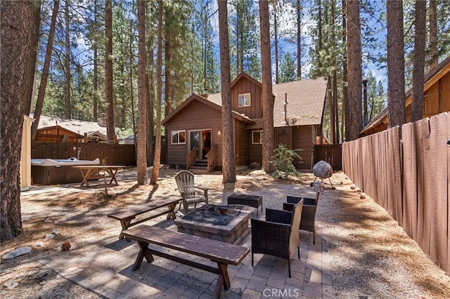 view of patio / terrace with an outdoor fire pit, a fenced backyard, and entry steps