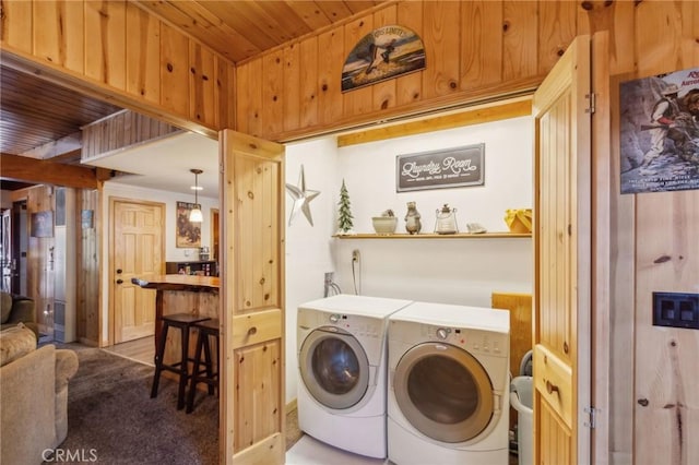 washroom with laundry area, wooden walls, wooden ceiling, carpet, and washer and dryer