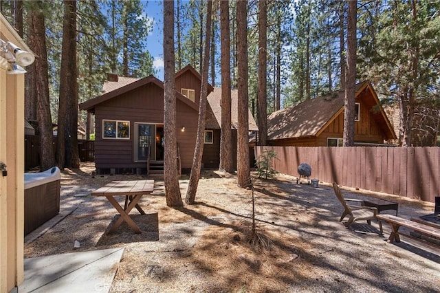 rear view of property with entry steps and a fenced backyard