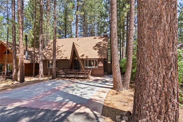 a-frame home with a shingled roof and driveway