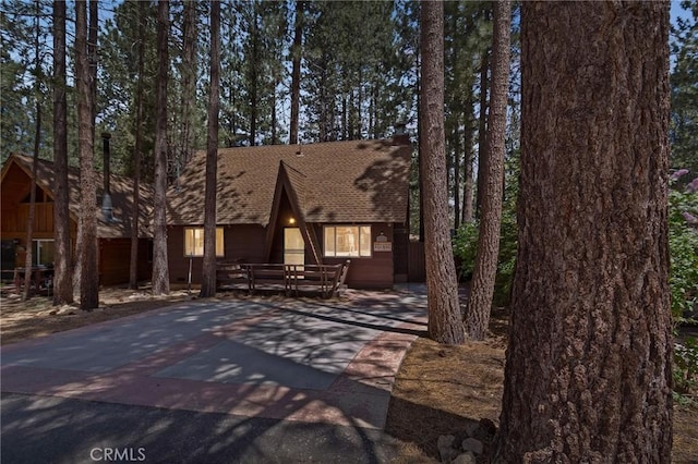 a-frame style home with roof with shingles