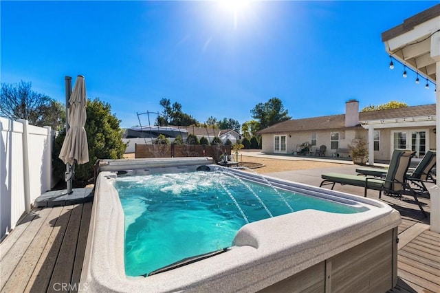 view of swimming pool featuring fence and a wooden deck