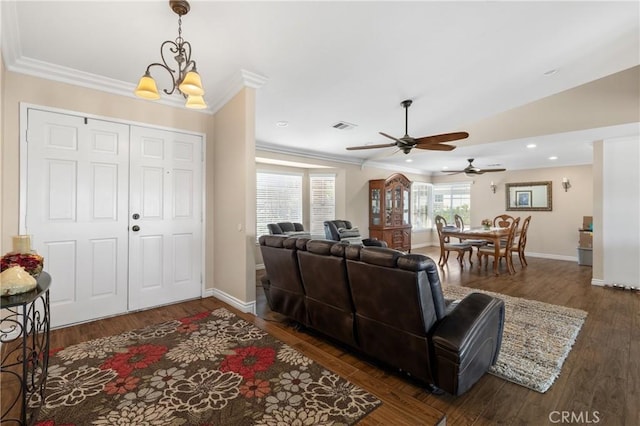 living area with a ceiling fan, wood finished floors, visible vents, baseboards, and crown molding