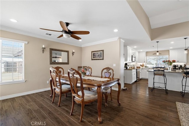 dining space featuring dark wood-style floors, baseboards, crown molding, and ceiling fan