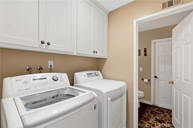 laundry room with cabinet space, visible vents, and washing machine and clothes dryer