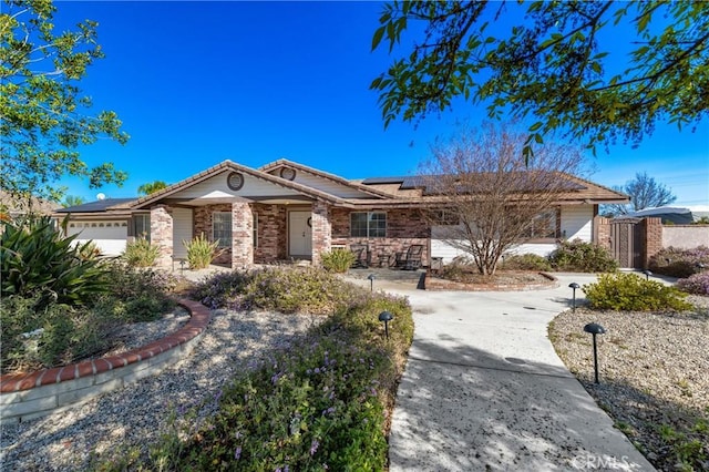 ranch-style house with solar panels, a garage, and driveway