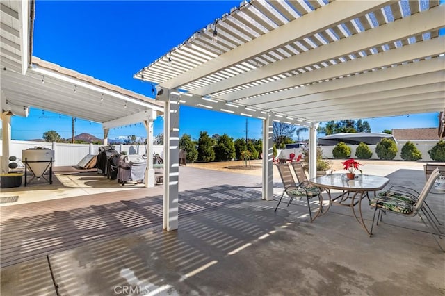 view of patio featuring a pergola, outdoor dining area, and fence