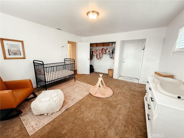 carpeted bedroom featuring visible vents and a sink