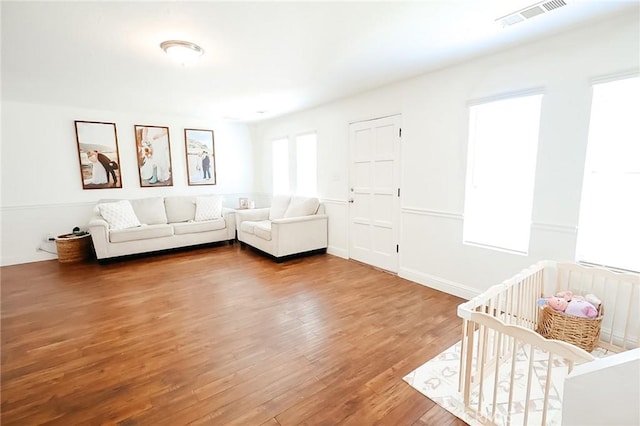 living area with wood finished floors and visible vents