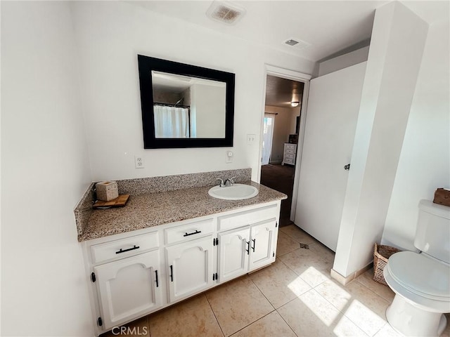 bathroom with visible vents, vanity, toilet, and tile patterned floors