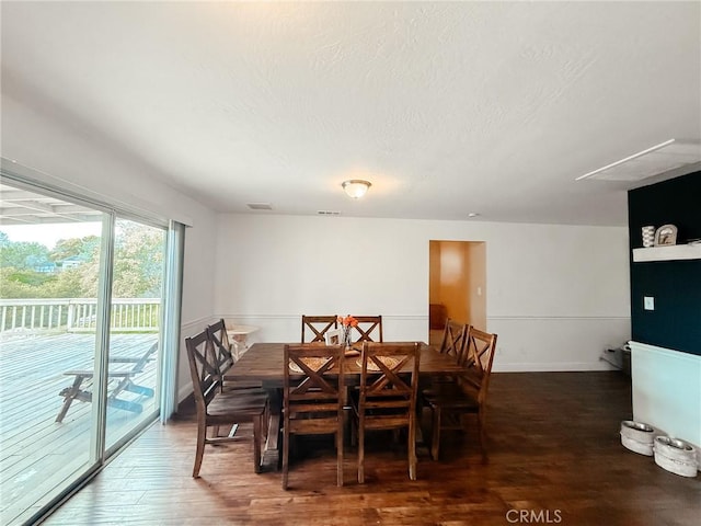 dining room featuring visible vents, a textured ceiling, baseboards, and wood finished floors