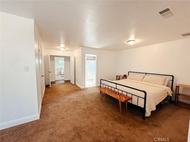 bedroom featuring ensuite bathroom, carpet flooring, visible vents, and baseboards