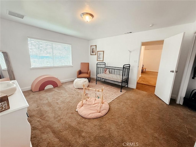 carpeted bedroom featuring visible vents and baseboards