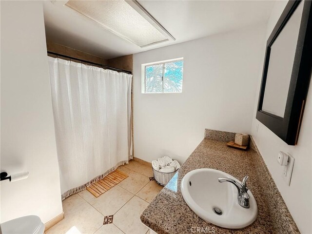 bathroom with tile patterned flooring, curtained shower, vanity, and toilet