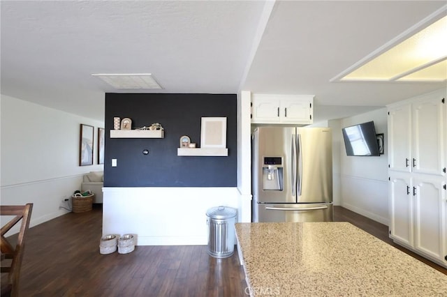 kitchen featuring baseboards, white cabinets, stainless steel fridge with ice dispenser, dark wood-style floors, and light stone counters