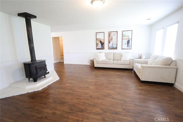 living room with a wood stove and dark wood-type flooring