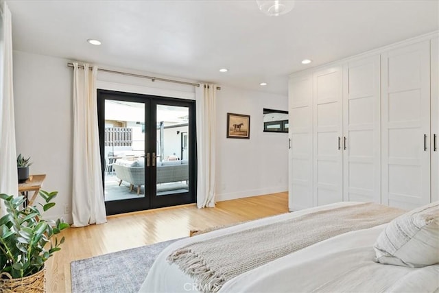 bedroom featuring access to exterior, light wood finished floors, baseboards, and french doors