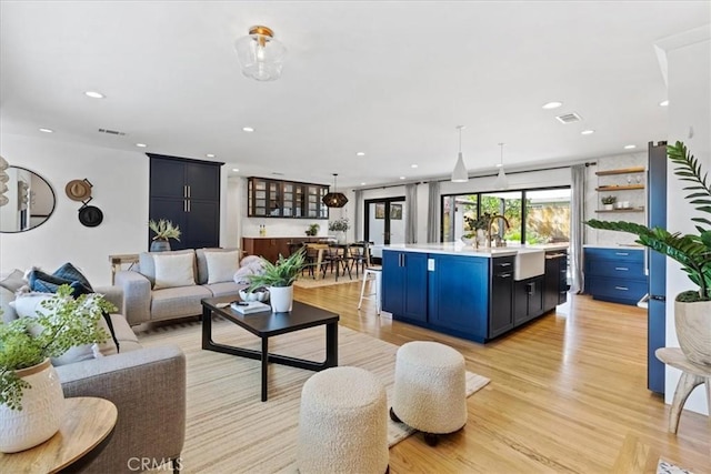 living room with recessed lighting, visible vents, and light wood-type flooring