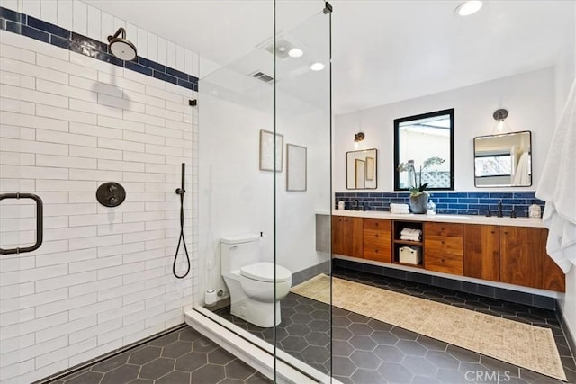 bathroom featuring vanity, visible vents, a stall shower, tile patterned floors, and toilet