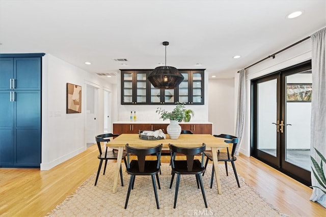 dining space with recessed lighting, french doors, and light wood-type flooring