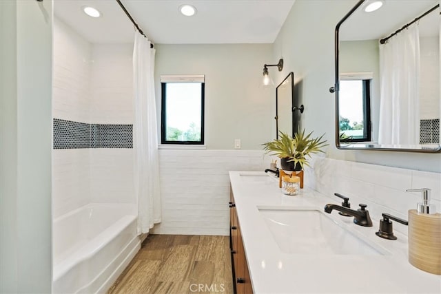 full bathroom with wood finished floors, a wainscoted wall, recessed lighting, a sink, and shower / bath combination with curtain