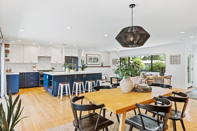 dining area featuring recessed lighting, light wood-type flooring, and baseboards