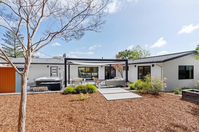 back of house featuring a patio area, stucco siding, a hot tub, and outdoor lounge area