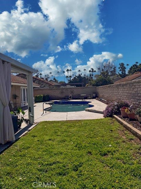 view of pool featuring a lawn, a patio area, a fenced backyard, and a fenced in pool