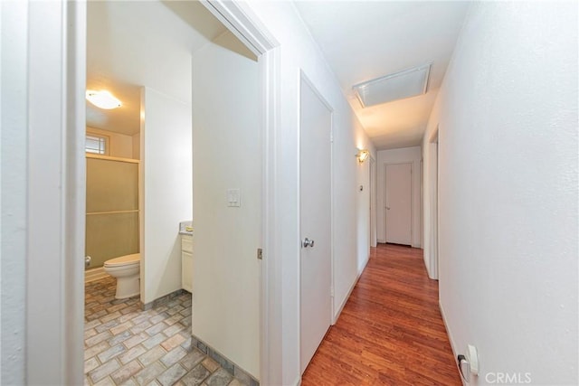 corridor with baseboards and light wood-style floors