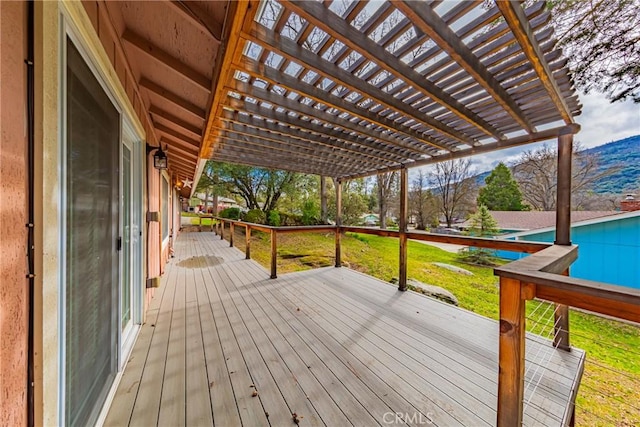 wooden deck with a lawn and a pergola