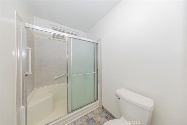 full bathroom with a shower with shower door and toilet