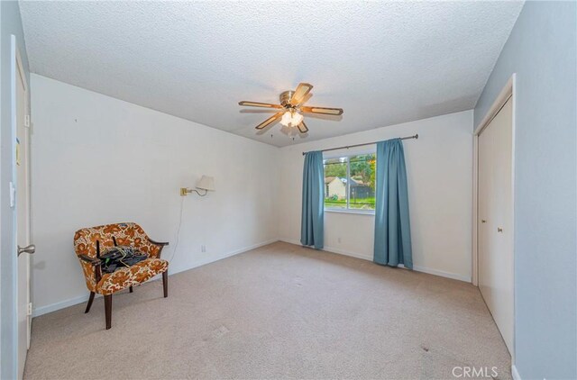 unfurnished room featuring a textured ceiling, carpet flooring, a ceiling fan, and baseboards