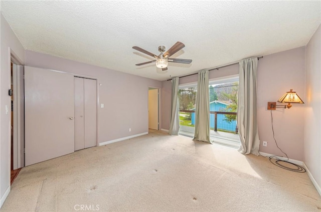 unfurnished bedroom featuring light carpet, access to exterior, and a textured ceiling