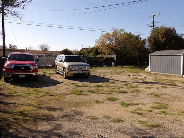 view of yard with an outbuilding, a shed, and fence