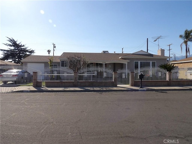 ranch-style house with a fenced front yard, a gate, and an attached garage