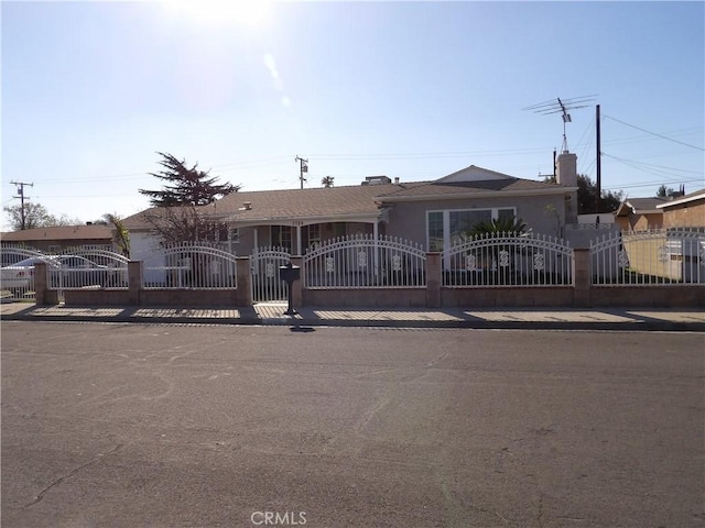 ranch-style home featuring a fenced front yard and a gate