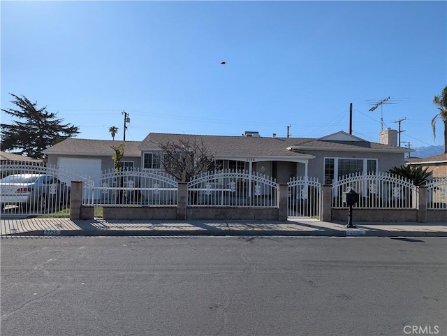 ranch-style home featuring a fenced front yard and a gate