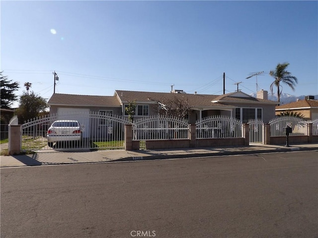 single story home featuring a fenced front yard, an attached garage, and a gate