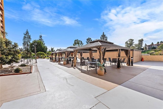 view of property's community featuring a gazebo, a patio area, and fence